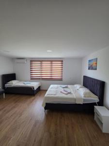a bedroom with two beds and a window at Apartmani gradina Tuzla in Tuzla