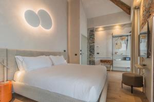 a bedroom with a large white bed and a chair at La Corte del Lario - La Cortesella in Varenna
