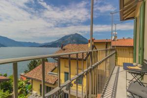a balcony with a view of the water and mountains at La Corte del Lario - La Cortesella in Varenna