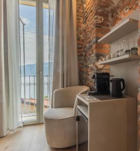 a kitchen with a chair in a room with a window at La Corte del Lario - La Cortesella in Varenna