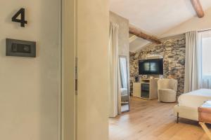 a living room with a stone wall and a television at La Corte del Lario - Contrada del Duca in Varenna +5 photos