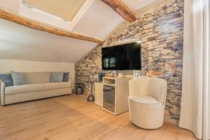a living room with a stone wall at La Corte del Lario - Contrada del Duca in Varenna