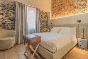 a bedroom with a bed and a chair and a window at La Corte del Lario - Contrada del Duca in Varenna
