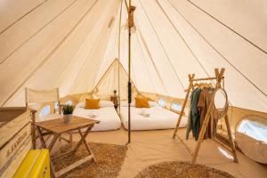 a tent with two beds and a table in it at Kampaoh Benicàssim in Benicàssim