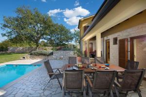 a patio with a table and chairs next to a pool at Vila Charlie in Labin