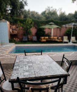 a table and chairs next to a swimming pool at Villas khadija in Marrakesh +20 photos