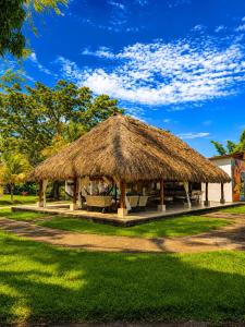 a hut with a straw roof on a grass field at Hotel Four20 Zensi - Meta in Lejanías