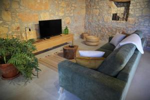 a living room with a couch and a flat screen tv at Casa do Ti Maurício in Gondemaria