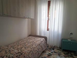 a small bedroom with a bed and a window at S'erribera de S'abiolu in Baunei