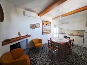 a kitchen and dining room with a table and chairs at S'erribera de S'abiolu in Baunei