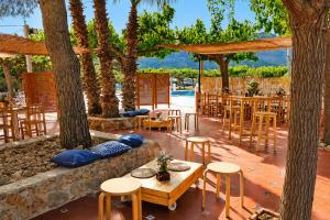 a patio with tables and chairs and trees at Kampaoh Benicàssim in Benicàssim