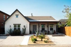 a white house with plants in front of it at Orion B, Vaulted Ceilings, Pool, Bunk Room in Port Isabel