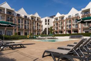 a group of apartment buildings with chairs and a pool at Résidence Pierre & Vacances L'Archipel in Perros-Guirec +75 photos