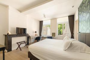 a bedroom with a large white bed and a desk at B&B Huyze Weyne in Bruges