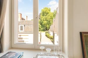 an open window with wine glasses on a table at B&B Huyze Weyne in Bruges