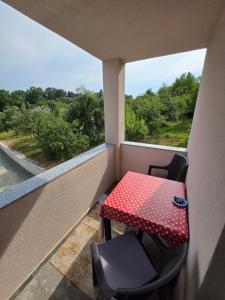 a table and chair in a balcony with a window at Apartmani gradina Tuzla in Tuzla