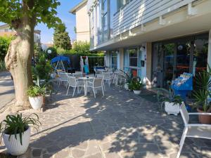 a patio with tables and chairs in front of a building at Hotel Mirage in Bellaria-Igea Marina