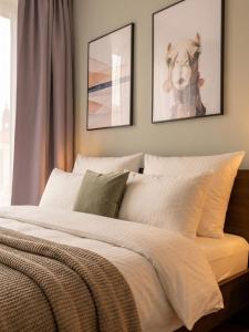 a bedroom with a white bed with two pictures on the wall at Limehome Dresden Wallstraße - Digital Access in Dresden