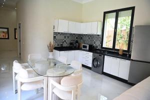 a kitchen with a glass table and white chairs at Villa Marrakech ,Piscine Privée & Luxe Authentique in El Aggada