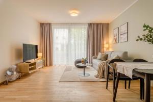 a living room with a couch and a tv at Limehome Dresden Wallstraße - Digital Access in Dresden