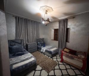 a bedroom with two beds and a chandelier at Villas khadija in Marrakesh
