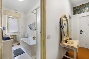 a white bathroom with a sink and a mirror at Pietra nel mare in Pietra Ligure