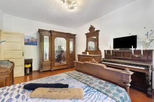 a bedroom with a piano and a bed with a bed sidx sidx at Pietra nel mare in Pietra Ligure