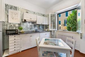 a kitchen with white cabinets and a table at Pietra nel mare in Pietra Ligure