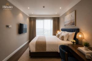 a hotel room with a bed and a desk and a television at Luxury Apartment - Rooftop Swimming Pool - Beach Front - Hinata Apartment in Danang