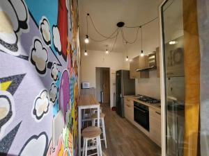 a kitchen with a wall with a painting of clouds at Casetta Lungomare in Pescara