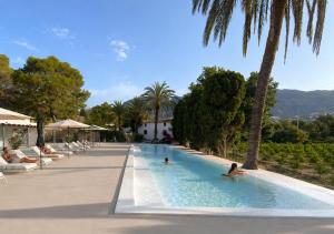 two people swimming in a swimming pool at a resort at Hotel Masía de Altea in Altea