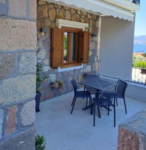 a patio with a table and chairs on a stone wall at Annie's cozy home in Mythimna