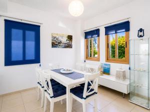 a dining room with a white table and chairs at Argaka Sunset Villa in Argaka