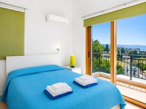 a bedroom with a blue bed and a balcony at Argaka Sunset Villa in Argaka +18 photos