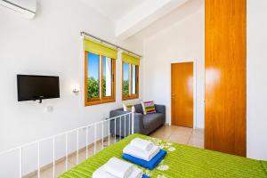 a living room with a bed and a tv at Argaka Sunset Villa in Argaka