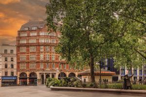 a painting of a large building in a city at Radisson Blu Hotel, London Leicester Square in London