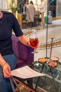a man sitting on a couch holding a wine glass at Radisson Blu Hotel Istanbul Pera in Istanbul