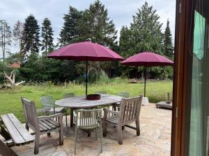 a table and chairs with umbrellas on a patio at Huis De Mijmering in Heikant