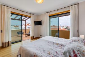 a bedroom with a bed and a view of a balcony at Algarve 360º Experience in Loulé
