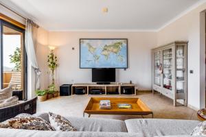a living room with a tv and a large screen at Algarve 360º Experience in Loulé