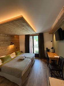 a hotel room with two beds and a desk at Hôtel et appart'hôtel de l'Hermitage in Thônes +95 photos