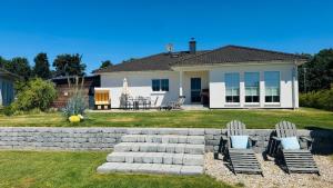 a house with two chairs in the yard at Casa Meeresbrise Marlow in Marlow