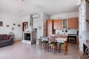 a kitchen and living room with a table and chairs at Le Crapare in Muro Leccese