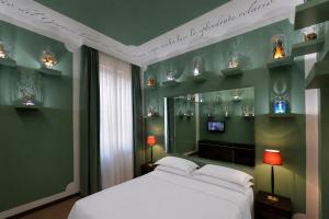 a bedroom with a white bed and green walls at Phi Hotel Bologna in Bologna