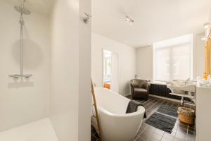 a bathroom with a white bath tub and a sink at B&B Huyze Weyne in Bruges +30 photos
