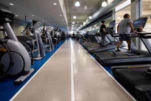 a gym with rows of treadmills and people walking on machines at Hotel Burnaby in Burnaby +6 photos