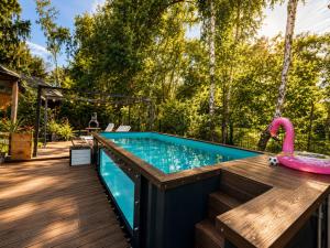 a swimming pool with a pink toy flamingo on a wooden deck at Family Resort in Dziwnów