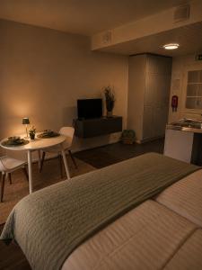 a bedroom with a bed and a table and a kitchen at Aldeia Bianca Lake Resort & Italian Restaurant in Kerimäki