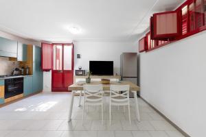 a kitchen with red cabinets and a table and chairs at cmv Salento in Marina di Pescoluse