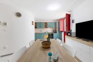 a kitchen with a wooden table with white chairs at cmv Salento in Marina di Pescoluse